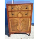 C20th figured walnut tallboy with two drawers with green composite handles, above a pair of doors,