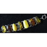 Hallmarked silver and amber bracelet, seven three tone butterscotch, orange and green amber beads
