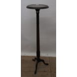 C20th mahogany torchiere with circular dished top, carved edge on circular tapering column,