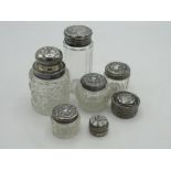 Collection of hallmarked sterling silver topped dressing table jars and two white metal lidded jars,