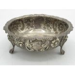 Hallmarked sterling silver dish, shaped rim, repousse with scrolls and flowers, three lion mask legs