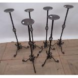 Six contemporary wrought iron candle stands, with circular drip tray, fluted and open column on