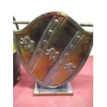 1950s brass armorial fire side companion stand in the form of a shield, an embossed magazine rack