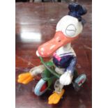 C20th celluloid Donald Duck toy, with fabric legs on green tinplate clockwork tricycle, H15cm