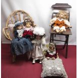 Five dolls including two porcelain with one wicker dolls/child's chair (6)