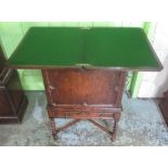 Early C20th oak drinks cabinet with swivel folding baise lined top, the moulded panel door with