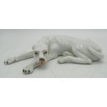 Early C20th Continental model of a recumbent hound, white glazed with black painted detail, L13cm