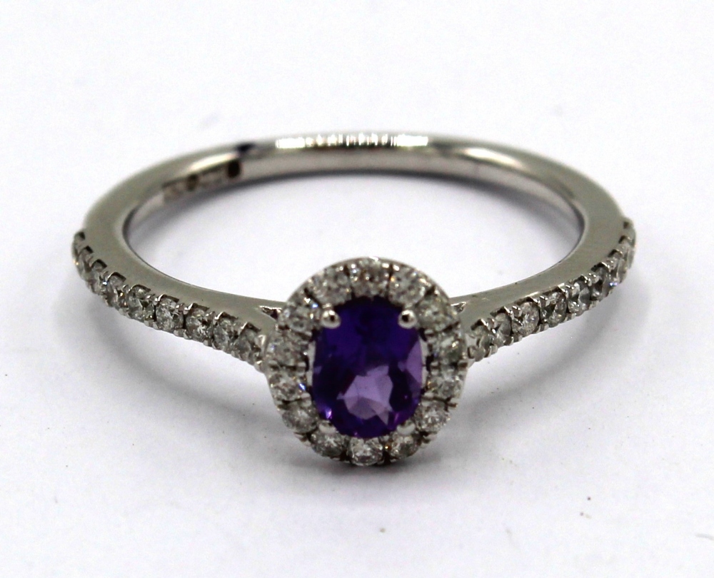 9ct white gold amethyst and diamond cluster ring, the oval cut amethyst surrounded by a halo of