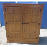 Alan Grainger Acorn Industries of Brandsby - an adzed oak panelled cupboard, with moulded top, two