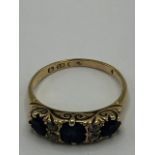 18ct yellow gold ring set with three sapphires and four diamonds in engraved mount, stamped 18ct,