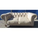 Chesterfield sofa, buttoned back and arms with two loose seat cushions on turned supports, W180cm