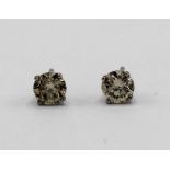 Pair of 14ct white gold solitaire diamond stud earrings, stamped 14ct, with silver butterfly backs