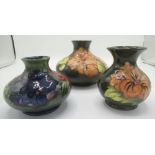 Moorcroft vase decorated with pink flowers on a green ground, similar smaller vase, another with