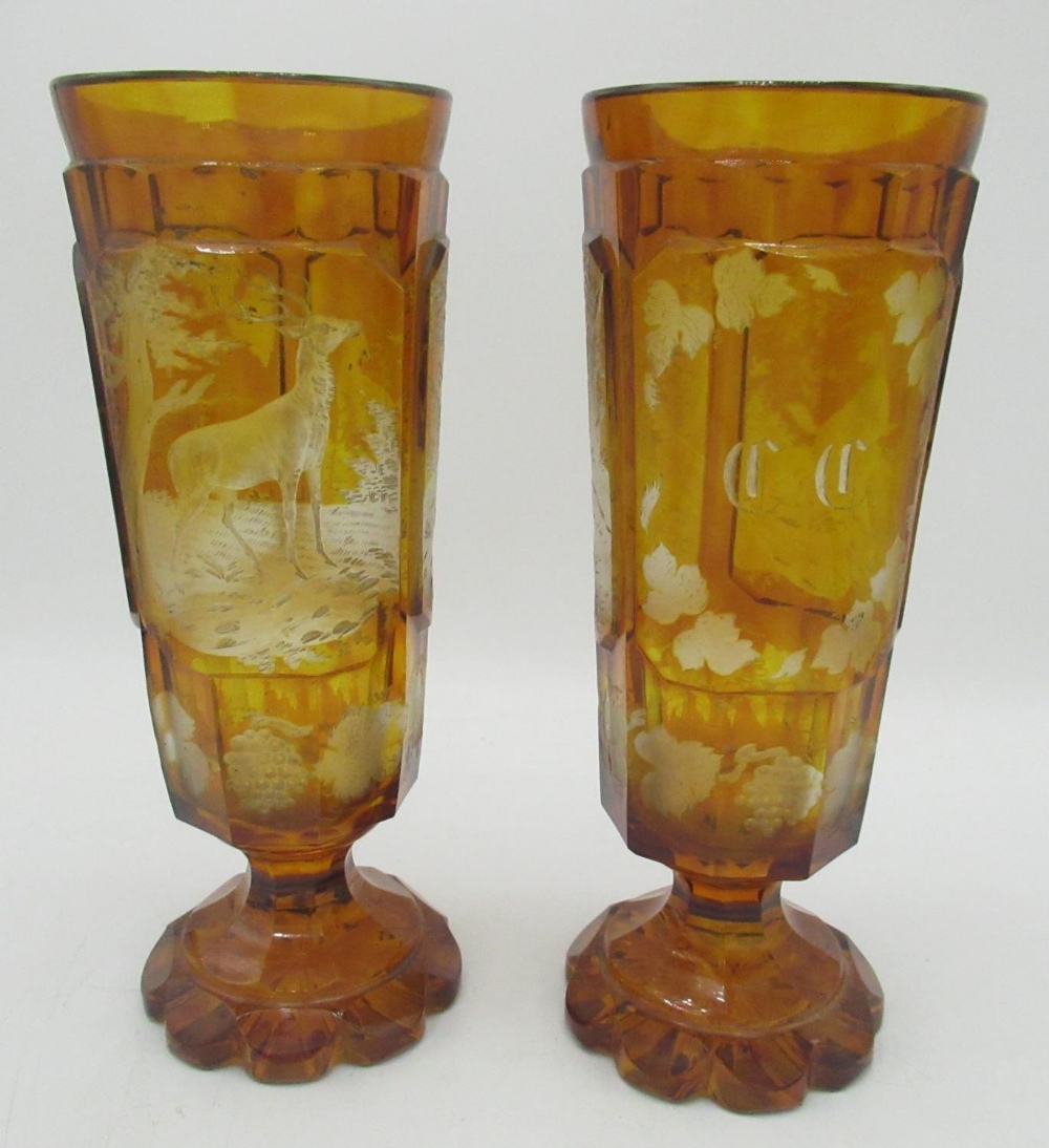 Pair of Bohemian amber glass Hunting goblets, tapering bowls etched in relief panels with Stag,