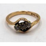 18ct gold ring, crossover set with three diamonds, stamped 18ct, size P, gross3.5g