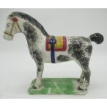 Prattware model of a horse, sponge decorated with black, blue ocre and red saddle and tack. on
