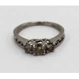 White gold diamond ring, the three central round cut diamonds set on a half eternity band, stamped