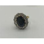18ct yellow gold sapphire and diamond cluster ring, the central oval cut sapphire surrounded by