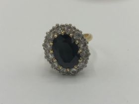 18ct yellow gold sapphire and diamond cluster ring, the central oval cut sapphire surrounded by