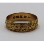 18ct yellow gold wedding band with foliage engraved design, stamped 18ct, size U, 4.7g