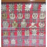 Framed and mounted display of 29 Scottish Regimental cap badges, including Tyneside Scottish,