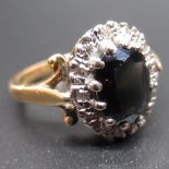 18ct yellow gold sapphire and diamond cluster ring, the central oval cut sapphire surrounded by a
