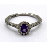 9ct white gold amethyst and diamond cluster ring, the oval cut amethyst surrounded by a halo of