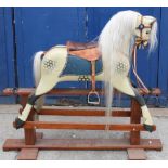 C20th rocking horse in dapple cream coat with white hair plume and tail, leather saddle and stirrups