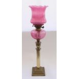 Early C20th brass fluted column oil lamp with cranberry glass reservoir and cranberry glass shade
