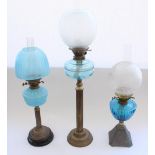 Three Victorian and later oil lamps with blue glass reservoirs (one opaline), later funnels and