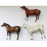 Three Beswick models of small thoroughbred stallions, including brown gloss, brown matte and grey,