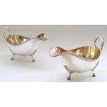 Victorian pair of hallmarked silver sauce boats with button border on raised lion paw feet.