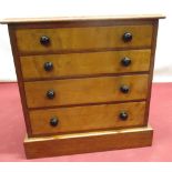 Small early C20th mahogany and maple chest of four graduated drawers with black glass handles, on