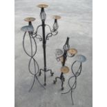 Graduated pair of black painted wrought metal tripod candlestands, on ropetwist supports, and a