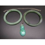 Pair of jade bangles, D7.4cm, and a carved jade pendant in the form of fruit (A/F) on white metal