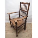 C20th North Country ash and elm spindle back rush seat elbow chair , turned supports with stretchers