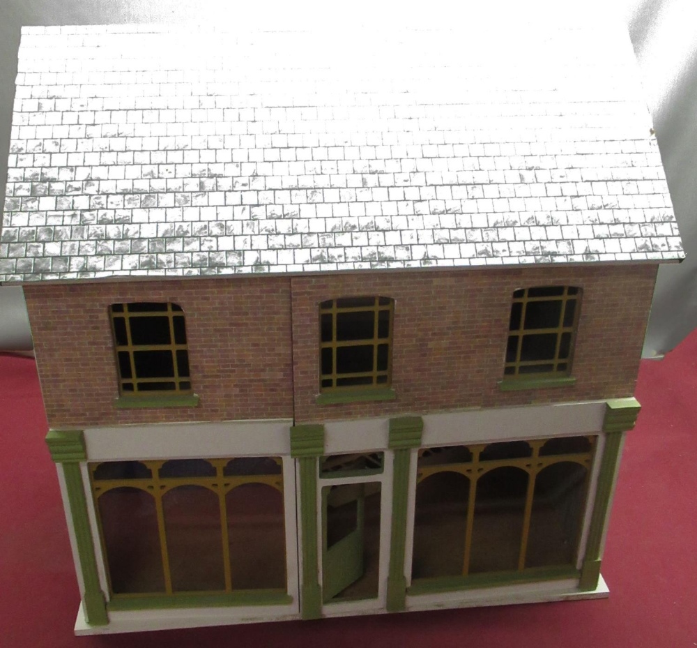 Modern dolls house in form of double fronted shop with unfinished interior, W60cm H60cm D39cm