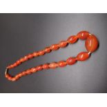 Amber bead necklace, single row of oval graduated beads, largest approx L2.5cm, with screw
