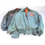 Three USAF type bomber jackets with various squadron patches and insignia