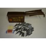 A collection of 12g CO2 capsules for air guns, an ammunition box for 7.62 blank rounds and a small