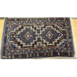 C20th Caucasian pattern wool rug, blue and brown ground, central field set with two stylised