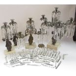 Garniture of three silvered metal candelabra, figural bases with urn sconces on white marble