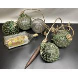 Two green and two clear glass fishing floats, a two masted and a three masted ship in bottle, and