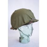 A US Army M1 Mk2 rear seam steel helmet, with liner, chin straps etc. Helmet has had markings