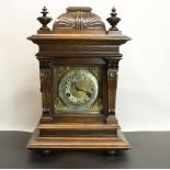 Junghans early C20th walnut cased mantel clock, carved caddy top with turned finial over carved