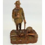 Bavarian painted carved softwood model of a Hunter with pipe, hound and rifle, on naturalistic base,