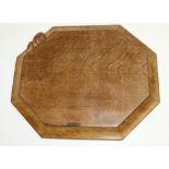 Robert Mouseman Thompson of Kilburn - an oak octagonal bread board, moulded edge carved with