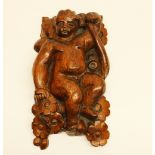 Late C18th carved oak model of a cherub seated naked with with flowers, H16cm W10cm