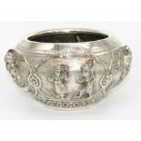 C20th Indian white metal circular bowl, decorated in high relief with panels of figures, in