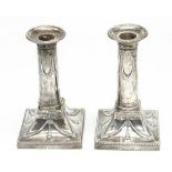 Pair of Edw.VII hallmarked silver gun barrel candlesticks with swag detail on square bases, by